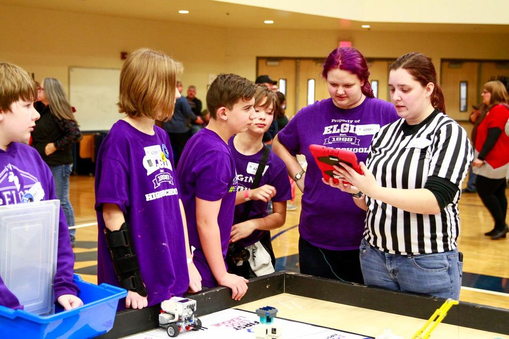 Lego team looks over their score with judge