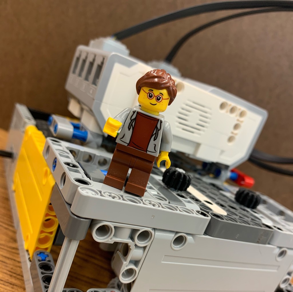 Lego girl standing on student built LEGO robot